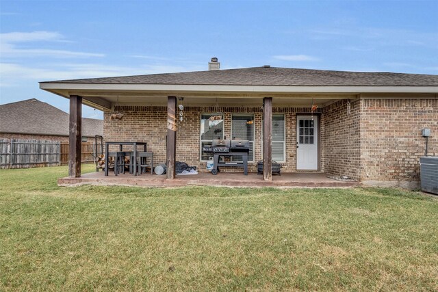 rear view of property featuring a lawn and a patio area