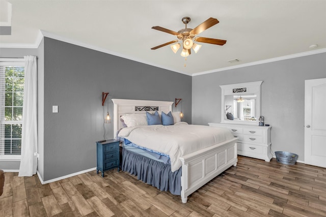 bedroom featuring ceiling fan, wood-type flooring, and crown molding