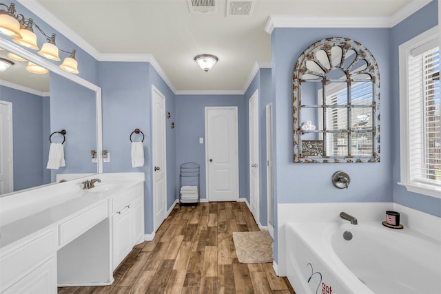 bathroom with a wealth of natural light, vanity, a bath, and hardwood / wood-style flooring