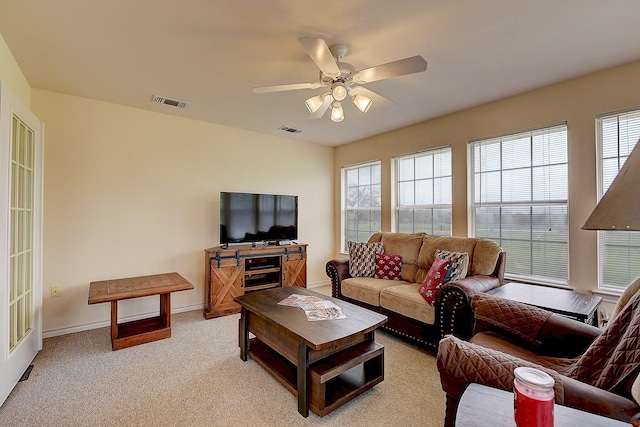 carpeted living room with ceiling fan