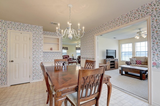 dining room with ceiling fan with notable chandelier