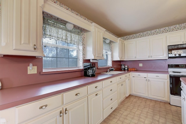 kitchen featuring white cabinetry, sink, and white range with electric stovetop