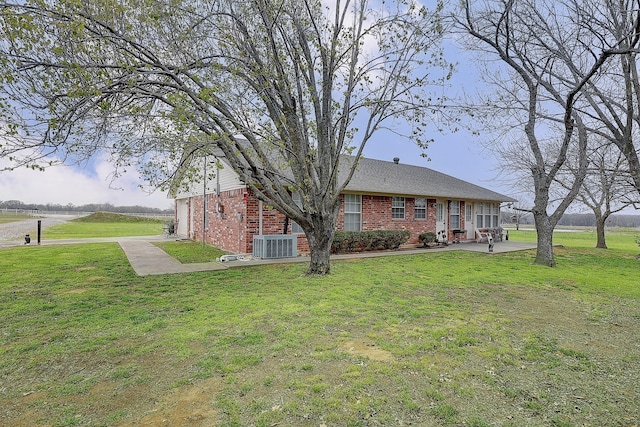 view of front of property with a front yard and central air condition unit