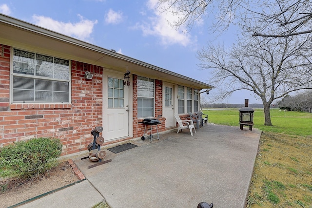 view of exterior entry featuring a patio and a yard