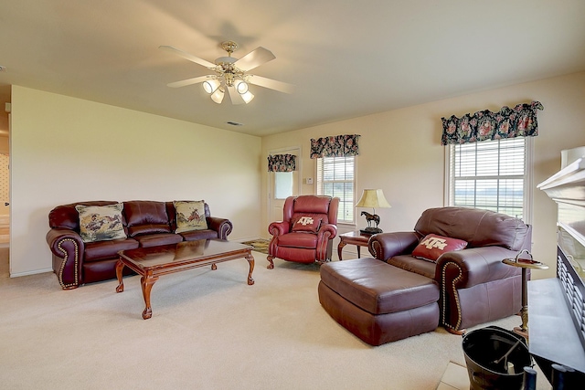 carpeted living room featuring ceiling fan, a fireplace, and a wealth of natural light