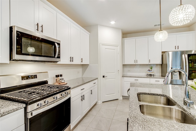 kitchen featuring appliances with stainless steel finishes, white cabinetry, decorative backsplash, and sink