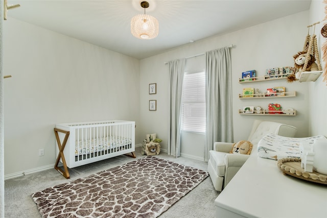 bedroom with a crib and carpet flooring