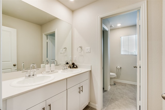 bathroom featuring tile patterned floors, double sink vanity, and toilet