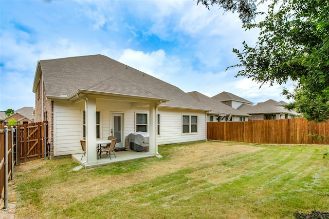 rear view of house featuring a patio and a yard