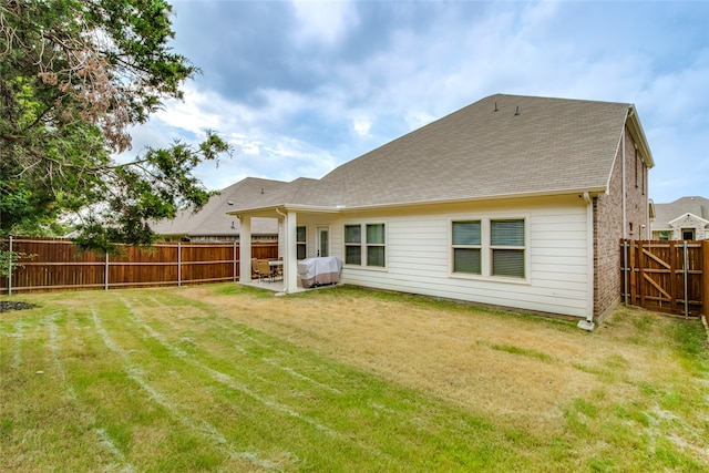 back of house featuring a patio and a yard