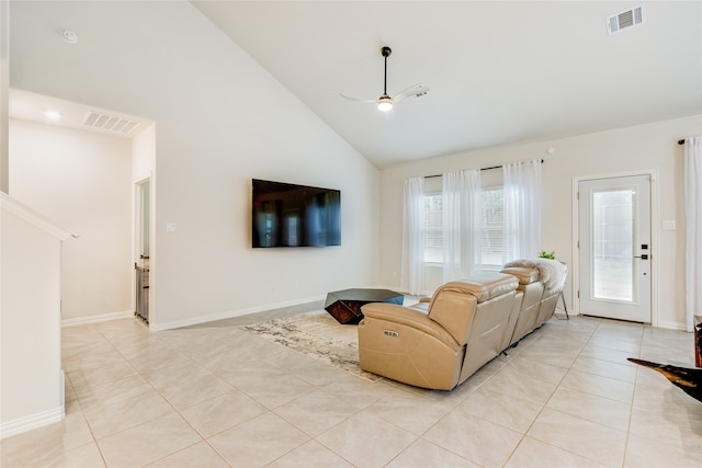 tiled living room with ceiling fan and high vaulted ceiling