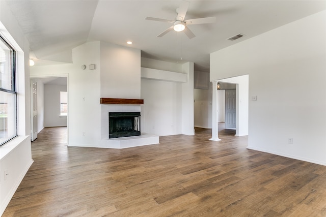 unfurnished living room featuring ceiling fan, hardwood / wood-style flooring, lofted ceiling, and a tile fireplace