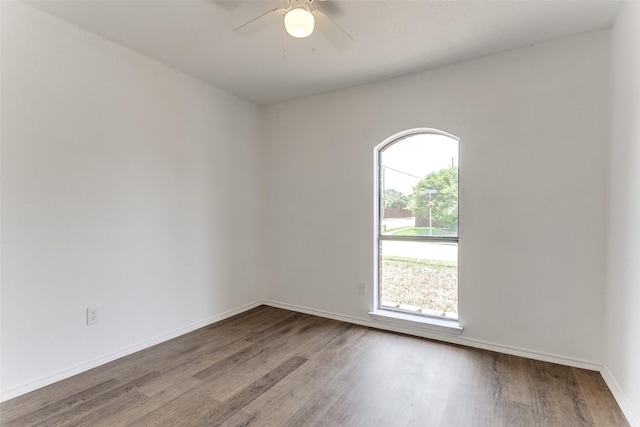 spare room featuring ceiling fan, wood finished floors, and baseboards