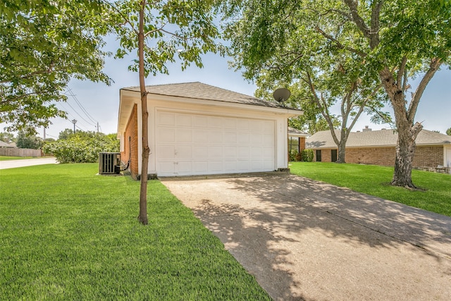 garage with central AC unit and a lawn