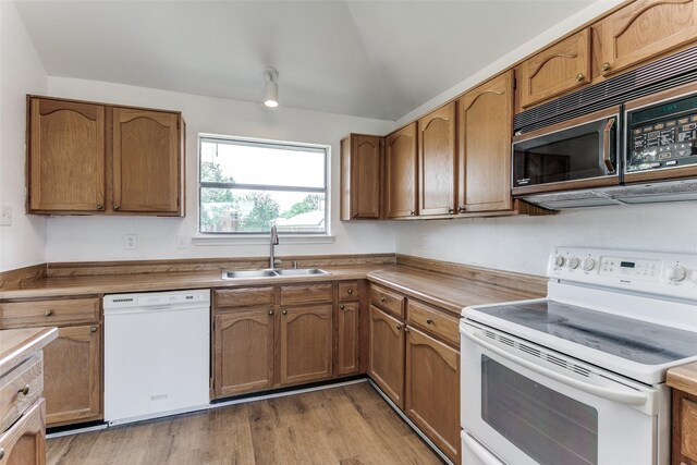 kitchen featuring white appliances, light hardwood / wood-style floors, and sink