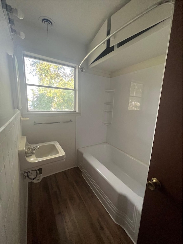 bathroom with hardwood / wood-style flooring, sink, and shower / tub combination