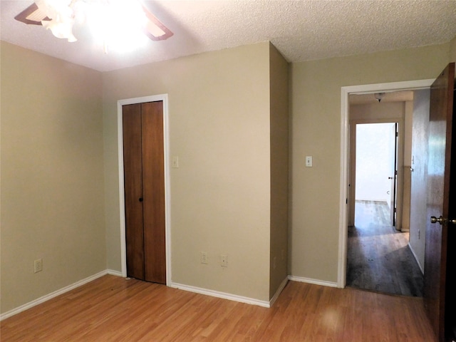 interior space featuring a closet, a textured ceiling, hardwood / wood-style floors, and ceiling fan