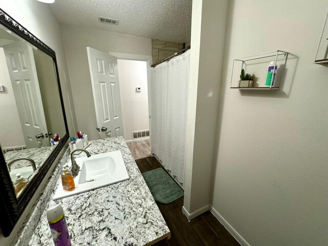 bathroom with vanity, a textured ceiling, and hardwood / wood-style flooring