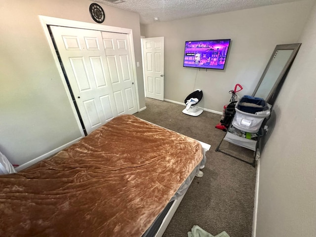carpeted bedroom featuring a closet, baseboards, and a textured ceiling