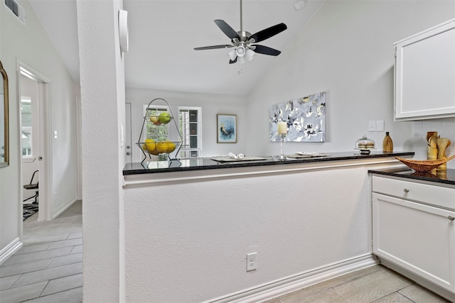 kitchen featuring white cabinetry, vaulted ceiling, and ceiling fan