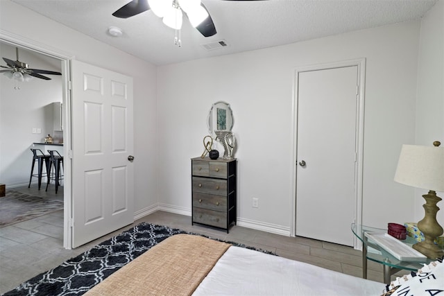 bedroom featuring ceiling fan and a textured ceiling