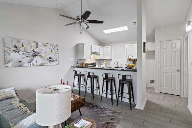 interior space featuring ceiling fan, dark hardwood / wood-style flooring, and lofted ceiling