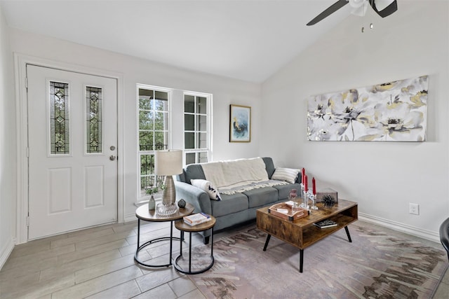 living room with ceiling fan, light hardwood / wood-style flooring, and vaulted ceiling