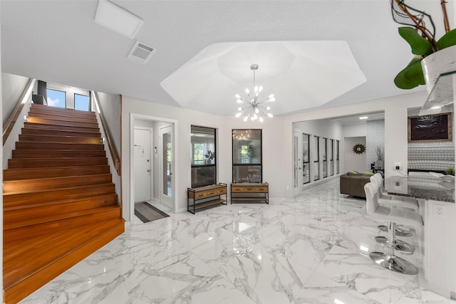 foyer entrance with a notable chandelier