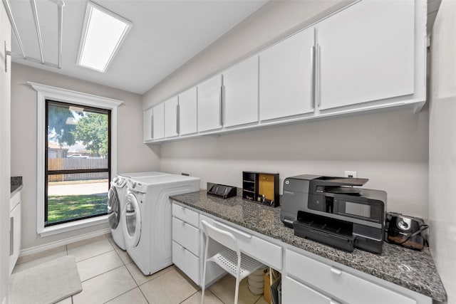 laundry area featuring cabinets, light tile patterned floors, and washer and clothes dryer