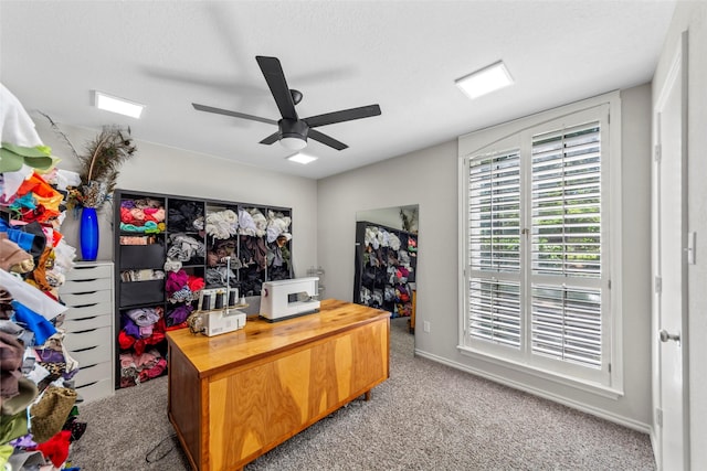 home office featuring light colored carpet, ceiling fan, and a textured ceiling