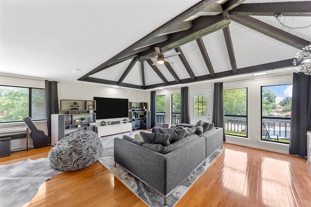 living room featuring light hardwood / wood-style floors, ceiling fan, and lofted ceiling with beams