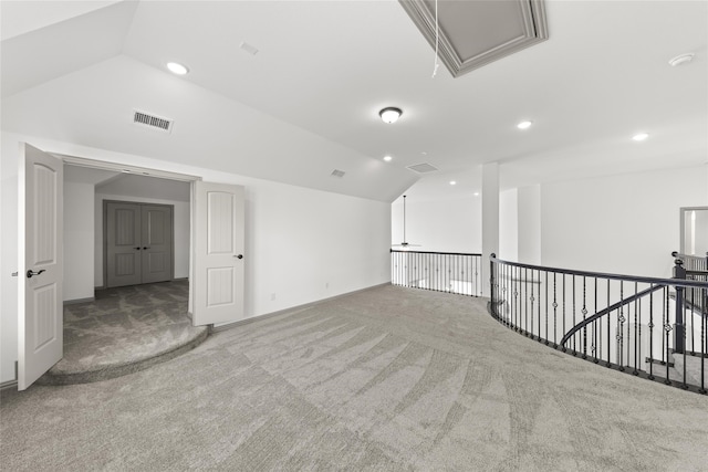 carpeted empty room with vaulted ceiling