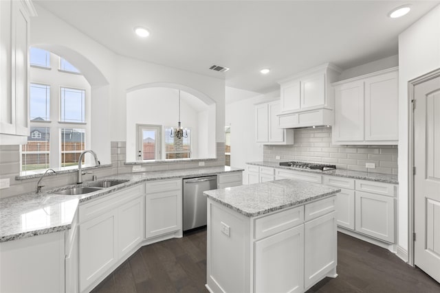 kitchen with sink, stainless steel appliances, a center island, and white cabinets