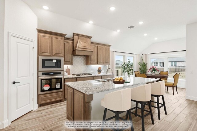 dining space with light hardwood / wood-style floors, vaulted ceiling, and a wealth of natural light