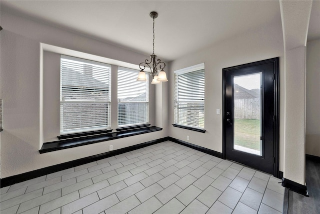 unfurnished dining area featuring light tile patterned floors and a notable chandelier