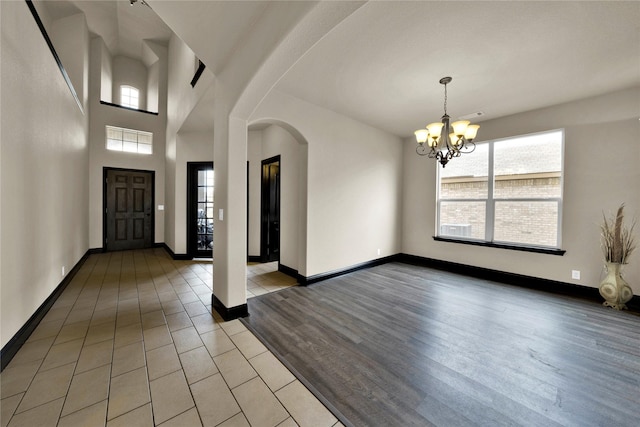 tiled entryway with a chandelier