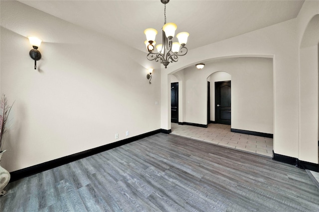 unfurnished room with a chandelier