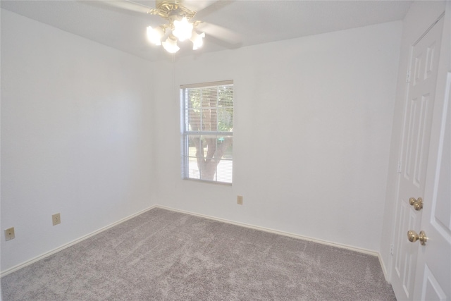 carpeted spare room featuring ceiling fan