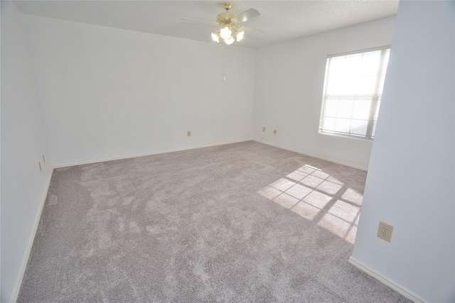 spare room with ceiling fan, light carpet, and a textured ceiling