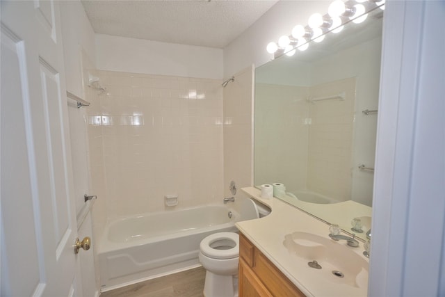 full bathroom with shower / bathing tub combination, vanity, wood-type flooring, a textured ceiling, and toilet