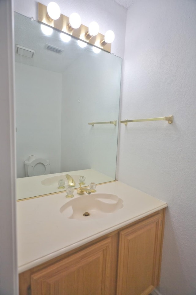 bathroom featuring vanity and toilet