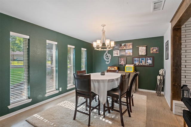 dining space featuring light hardwood / wood-style flooring and a notable chandelier