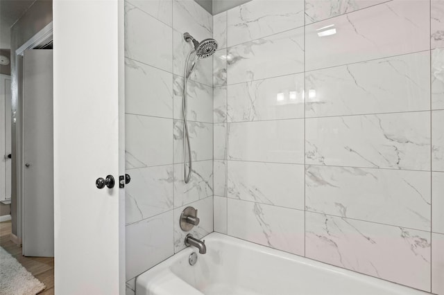 bathroom featuring hardwood / wood-style flooring and tiled shower / bath