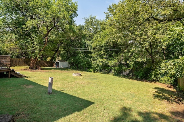 view of yard with a shed and a fire pit