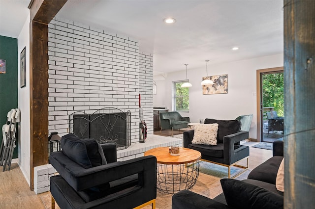 living room with light hardwood / wood-style floors, plenty of natural light, and a fireplace