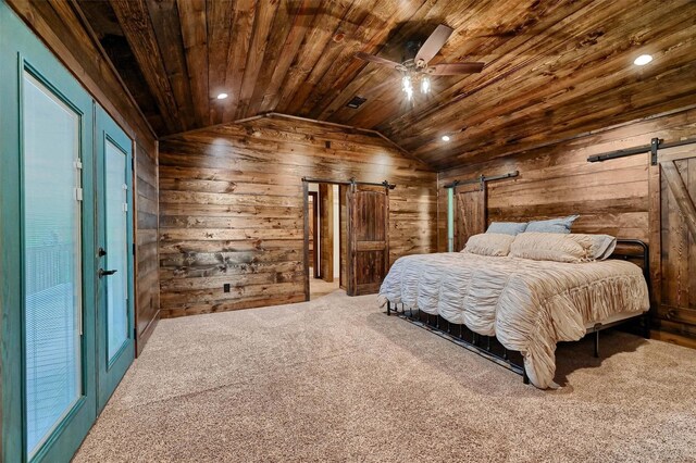 bedroom with lofted ceiling, a barn door, ceiling fan, wooden walls, and wood ceiling