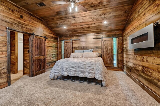 carpeted bedroom featuring wood ceiling, a barn door, wood walls, ceiling fan, and vaulted ceiling