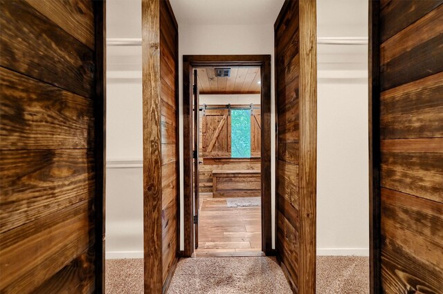 spacious closet featuring a barn door and carpet flooring