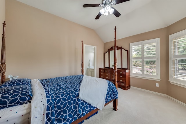 carpeted bedroom with ceiling fan, vaulted ceiling, and ensuite bath