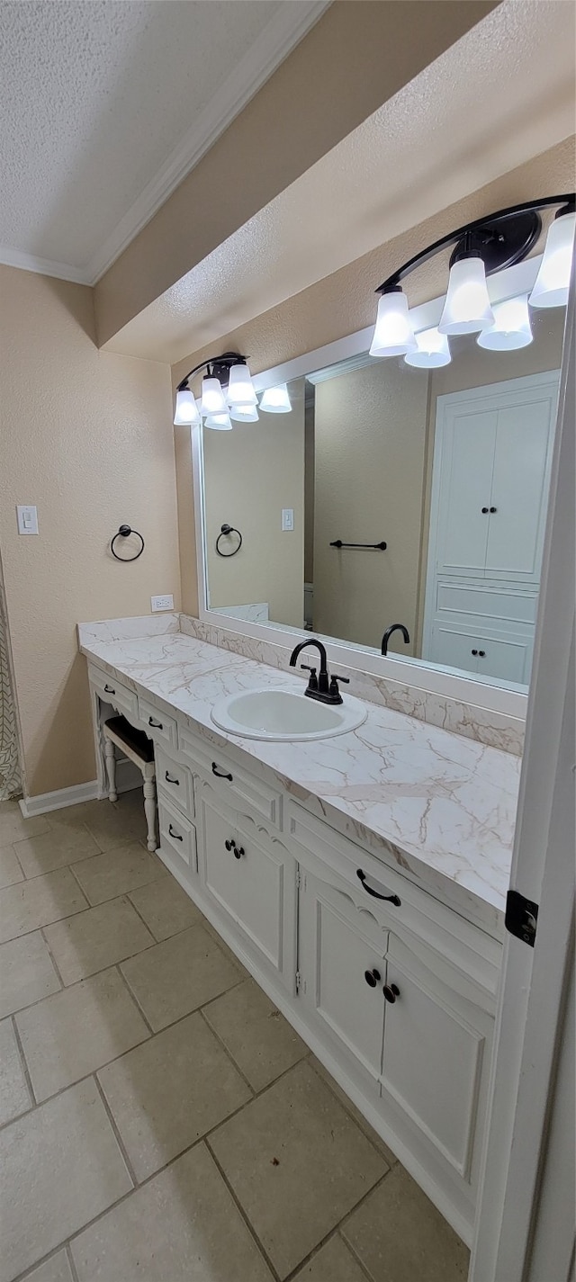 bathroom featuring vanity, a textured ceiling, tile patterned flooring, and crown molding